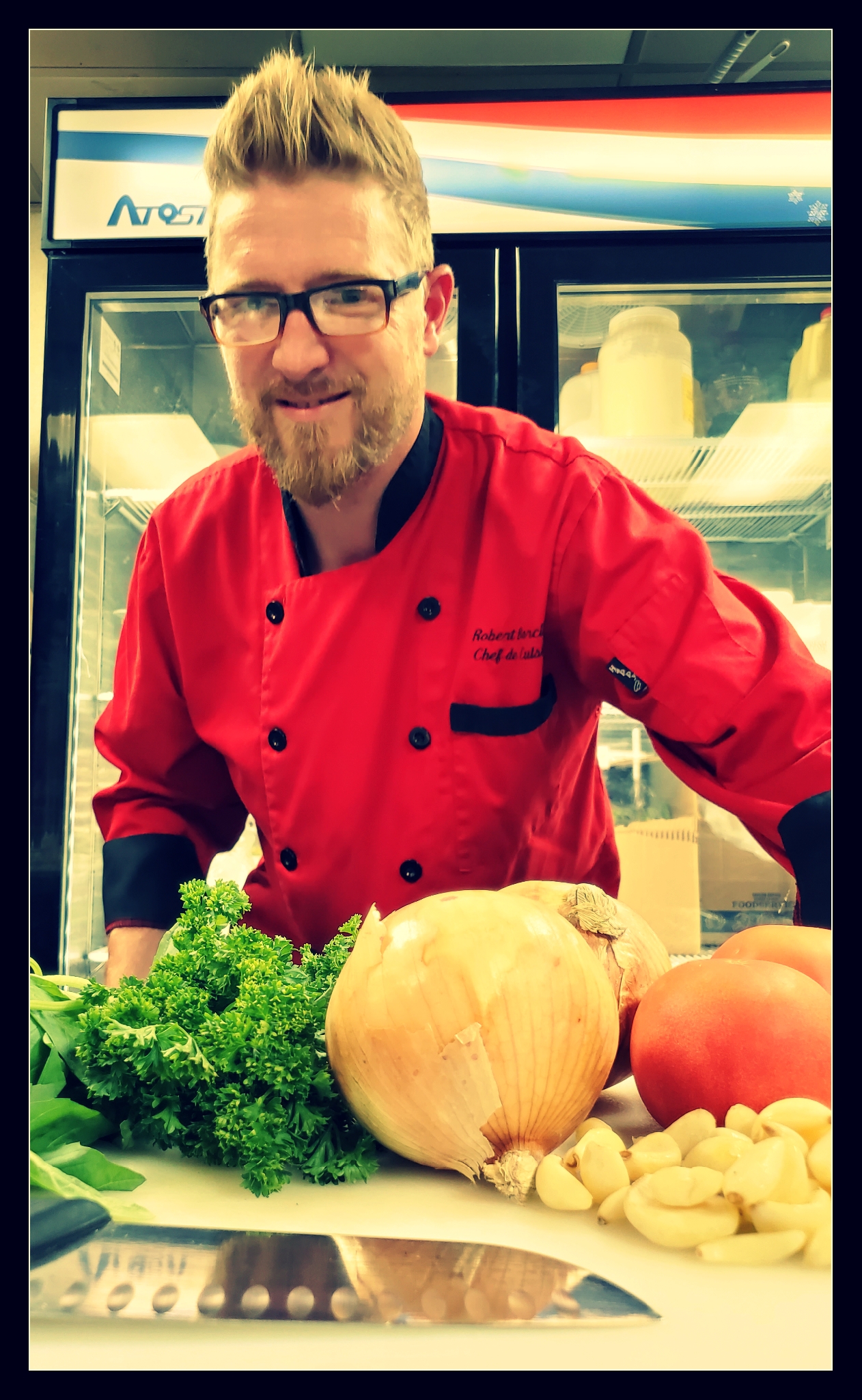 Chef in kitchen with vegetables and chef's knife